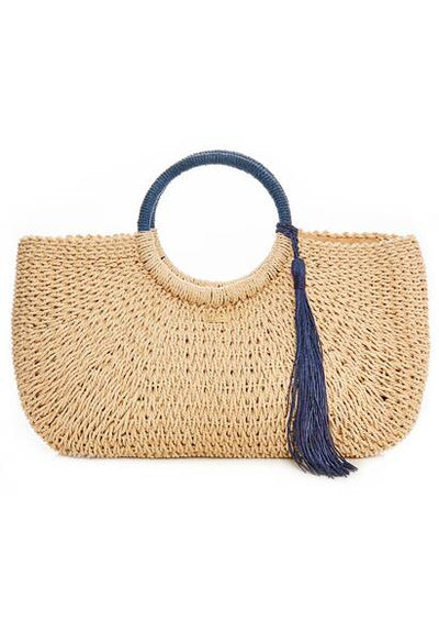 Die handgefertigte Strandtasche „Sorrento“ von Melissa Odabash in natürlichem Beige mit stilvollen blauen Quasten – perfekte Begleiterin für elegante Sommer-Looks